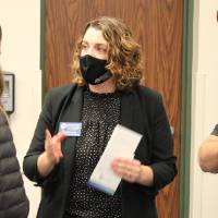 Two faculty discuss with another student